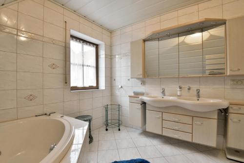 a bathroom with a tub and a sink and a mirror at Haus Martha Suhl in Suhl