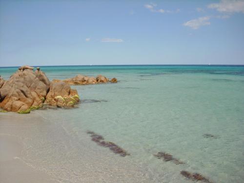 a beach with some rocks in the water at Residence Bouganvillage in Budoni