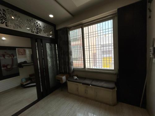 a room with a bench in front of two windows at Rukmani Kunj in Varanasi