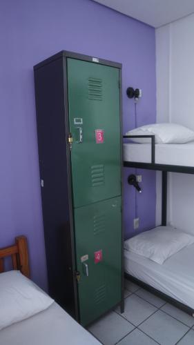 a green locker in a room with two bunk beds at POA Eco Hostel in Porto Alegre