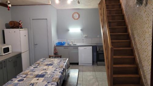une petite cuisine avec une table et un escalier dans l'établissement maison de vacances FRECONRUPT, à La Broque