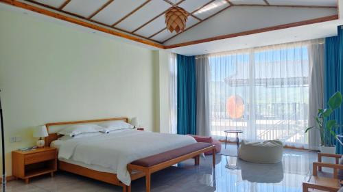 a bedroom with a bed and a large window at Avatar Hilltop Manor B&B in Zhangjiajie