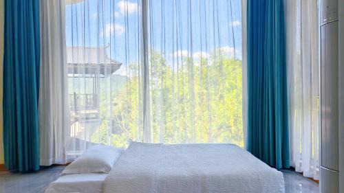 a bedroom with a bed and a large window at Avatar Hilltop Manor B&B in Zhangjiajie