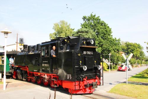 a man is standing inside of a black train at strandnah, gratis Nutzung vom AHOI Erlebnisbad und Sauna in Sellin - Kurparkresidenz FeWo10 in Baabe