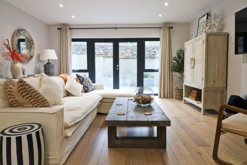 ein Wohnzimmer mit einer weißen Couch und einem Tisch in der Unterkunft Fifty Steps from the beach! in Saint Merryn