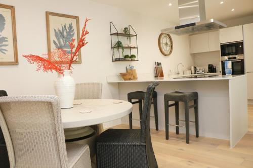 eine Küche und ein Esszimmer mit Tisch und Stühlen in der Unterkunft Fifty Steps from the beach! in Saint Merryn