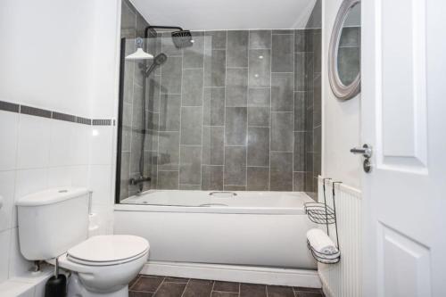 une salle de bain avec une baignoire blanche et des toilettes dans l'établissement Doulton House - 2 Bedroom Sleeps 5 Wifi Parking, à Wharton