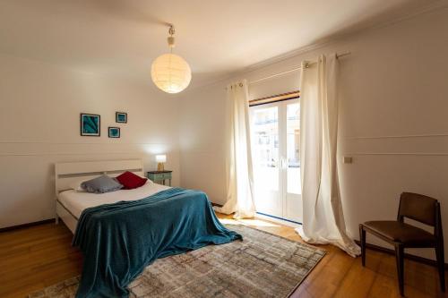 Un dormitorio con una cama y una ventana grande. en Villa Brisa do Mar, en Ericeira