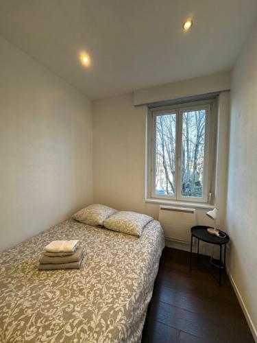 une petite chambre avec un lit et une fenêtre dans l'établissement # Le 11 # Joli F2 rénové, centre, à Mulhouse
