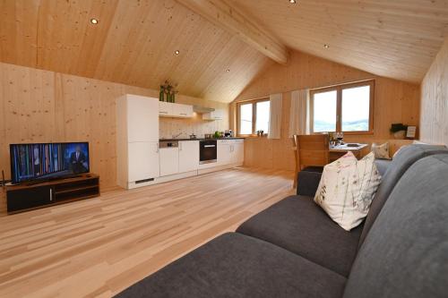 a living room with a couch and a kitchen at Ferienhof Landerleben in Egg