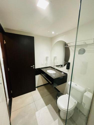 a bathroom with a toilet and a sink at Ritz Paradise Beira Mar no Hotel Ritz Suítes in Maceió
