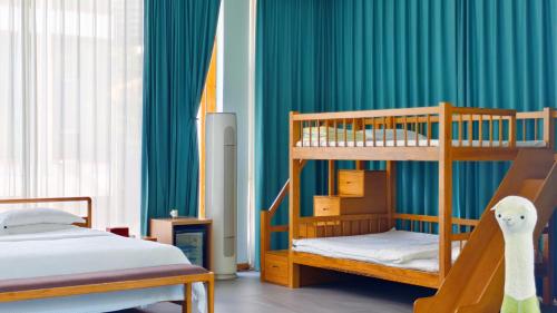 two bunk beds in a room with green curtains at Avatar Hilltop Manor B&B in Zhangjiajie