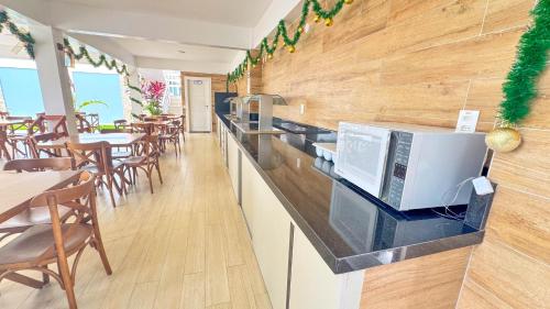a restaurant with a counter with a microwave on it at Pousada Diane in Trairi