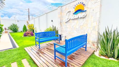 two blue benches sitting in front of a building at Pousada Diane in Trairi