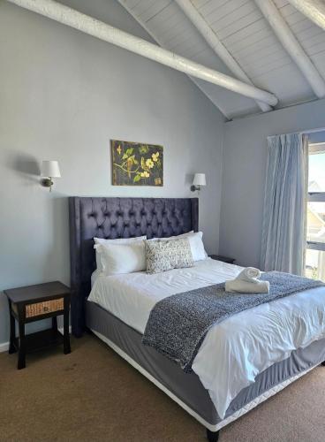 a bedroom with a large bed and a window at Ibis 1 in Cape St Francis Resort in Cape St Francis
