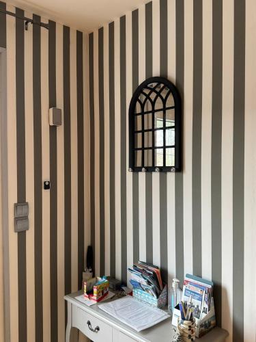 - un bureau dans une chambre avec un mur rayé dans l'établissement Le Rivage, Maison avec jardin proche de la mer, à Saint-Aubin-sur-Mer