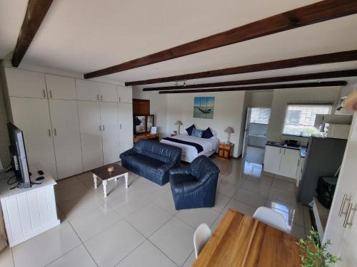 a living room with a bed and a couch at Eagles Rest Guest House in Summerstrand