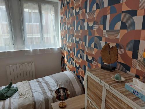 une chambre avec un lit et un mur dans l'établissement Agréable studio -1 personne, à Dijon