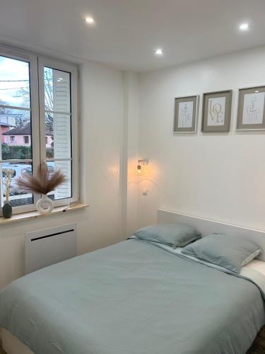 une chambre blanche avec un lit et une fenêtre dans l'établissement Escapade Thermale, à Lons-le-Saunier