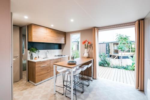 a kitchen with a counter with stools and a table at Marino Mobilhomes in Grimaud