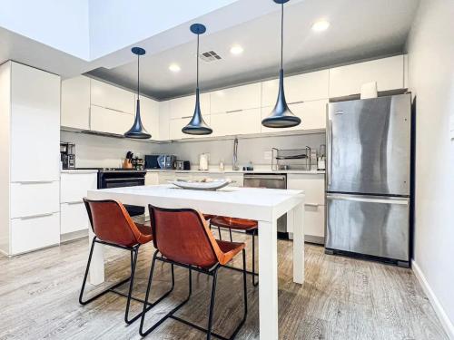 cocina con mesa blanca y 4 sillas en Bright 2-BR Home Near LAX with Shared Yard - SH2-LAD, en Los Ángeles