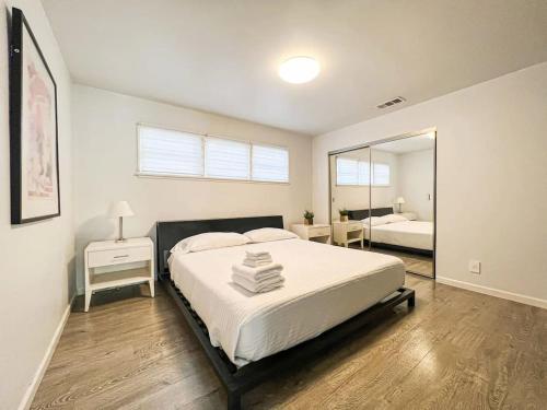 Un dormitorio con una cama grande y un espejo. en Bright 2-BR Home Near LAX with Shared Yard - SH2-LAD, en Los Ángeles