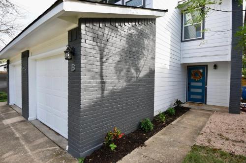 a house with a blue door and a garage at Stylish 2 suite condo minutes to food, music, fun in Austin