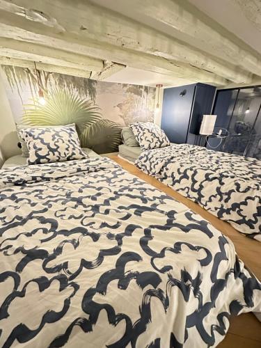 une chambre avec deux lits et un canapé dans l'établissement Cosy Flat In Marais, à Paris