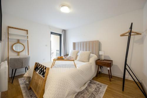 a bedroom with a bed with a table on it at Modern Flat, Oxford city centre in Oxford
