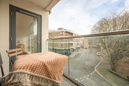 a balcony with a view of a street from a window at Modern Flat, Oxford city centre in Oxford