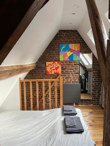 - une chambre mansardée avec un lit et un mur en briques dans l'établissement Appartement Vieux Lille à 300m de Grand Place, à Lille