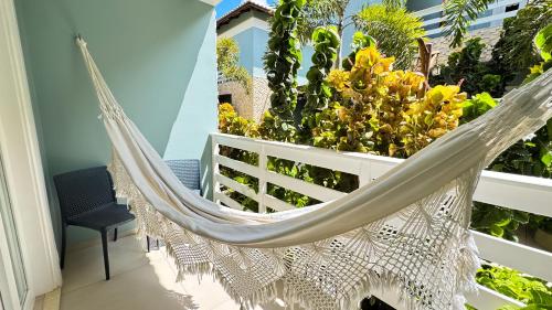 a hammock on a balcony with plants at Pousada Diane in Trairi