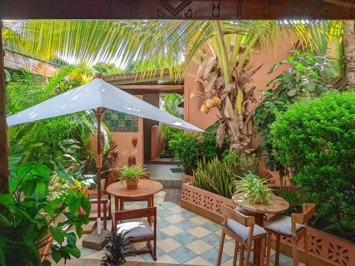 an outdoor patio with tables and chairs and plants at LE NOUVEL EDEN in Toliara