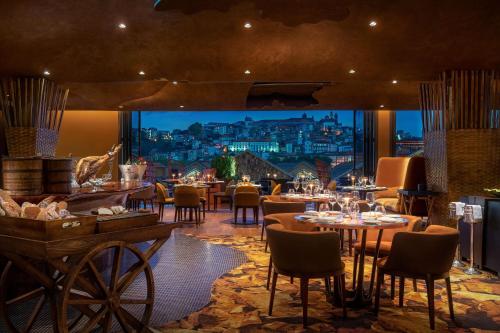 a restaurant with tables and chairs and a view of a city at Forte de Gaia, Autograph Collection in Vila Nova de Gaia