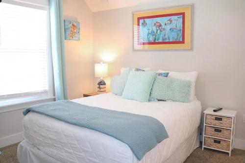 a bedroom with a large white bed with blue pillows at Chalet Mer in Blue Gulf Beach
