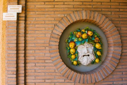 a statue of a face on a brick wall at Boteroom Relais in La Volla