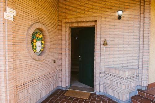 a door to a brick building with a wreath on it at Boteroom Relais in La Volla