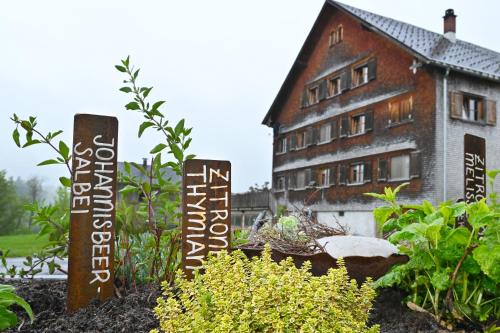 a garden with signs in front of a building at Ferienhof Landerleben in Egg