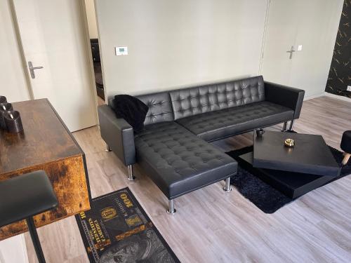un salon avec un canapé en cuir et une table dans l'établissement Appartement, à Saint-Étienne