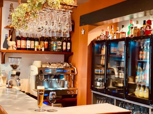 - un bar avec de nombreuses bouteilles et verres sur le mur dans l'établissement Hôtel Saint-Roch, Saint-Ybard, à Saint-Ybard