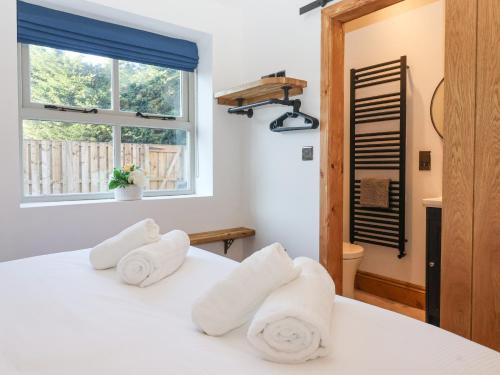 ein Schlafzimmer mit einem weißen Bett mit Handtüchern darauf in der Unterkunft Beth's Cottage in Malton