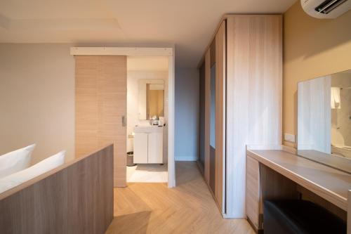 a room with a bathroom with a sink and a mirror at Triple Four in Bangkok