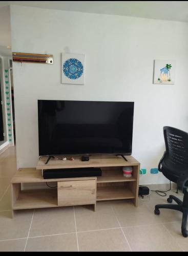 Ein Flachbildfernseher steht auf einem hölzernen Unterhaltungsmöbel. in der Unterkunft Apartamento Dormitorio 2 in Santa Marta