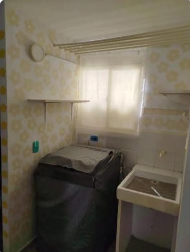 ein kleiner Raum mit einem Mülleimer und einem Waschbecken in der Unterkunft Apartamento Dormitorio 2 in Santa Marta
