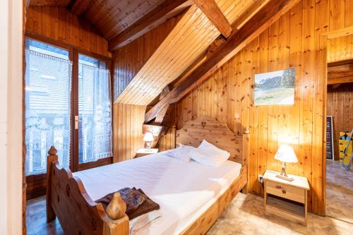 a bedroom with a bed in a wooden room at Nature l'été et ski l'hiver in Moutiers
