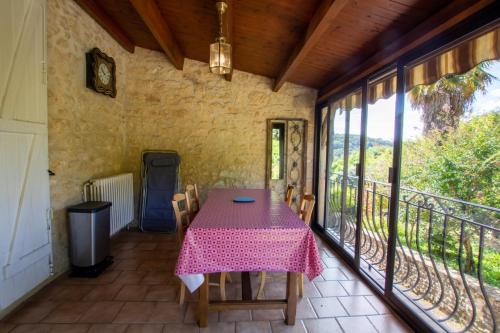 une pièce avec une table et des chaises sur un balcon dans l'établissement Les palmiers, à La Roque-Gageac