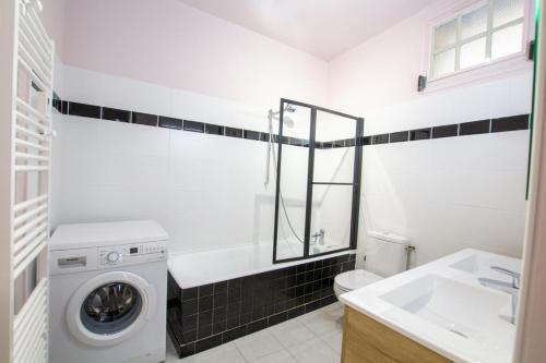ラ・ロック・ガジャックにあるLes palmiersの洗濯機と洗面台を備えたバスルーム
