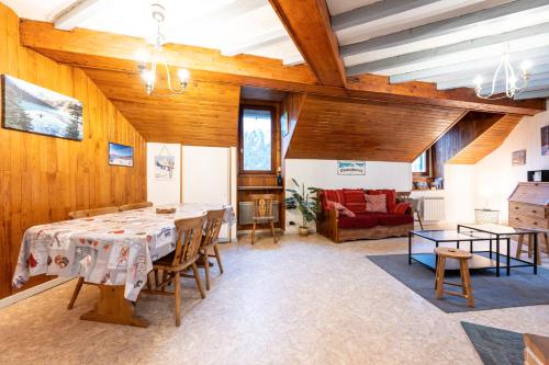 une salle à manger avec une table et un canapé dans l'établissement Nature l'été et ski l'hiver, à Moutiers