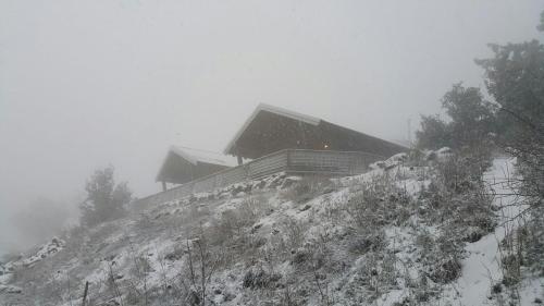 a house on top of a snow covered mountain at Gilad Cabins in Odem