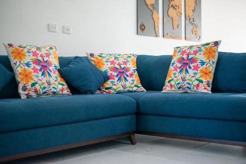 eine blaue Couch mit bunten Kissen drauf in der Unterkunft Perfect resort style House in Playa del Carmen
